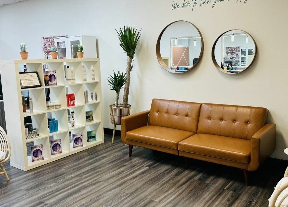 Stylish seating area at Cactus Salon in Addison, Texas, US showcasing modern decor and beauty products.