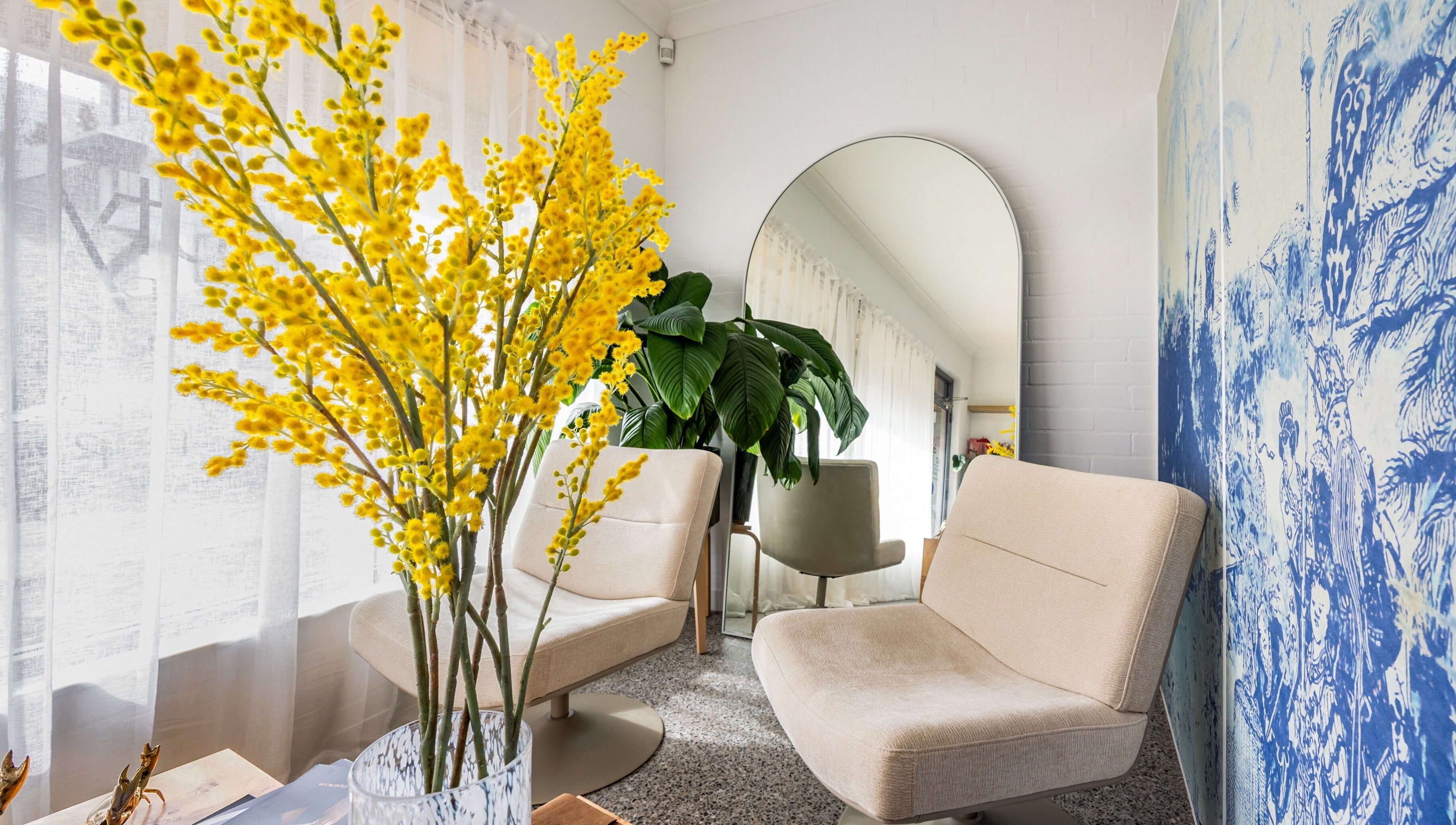 Chic lounge area at Bare Beauty Clinic Sydney, featuring plush chairs and vibrant decor. Sydney, NSW, AU.