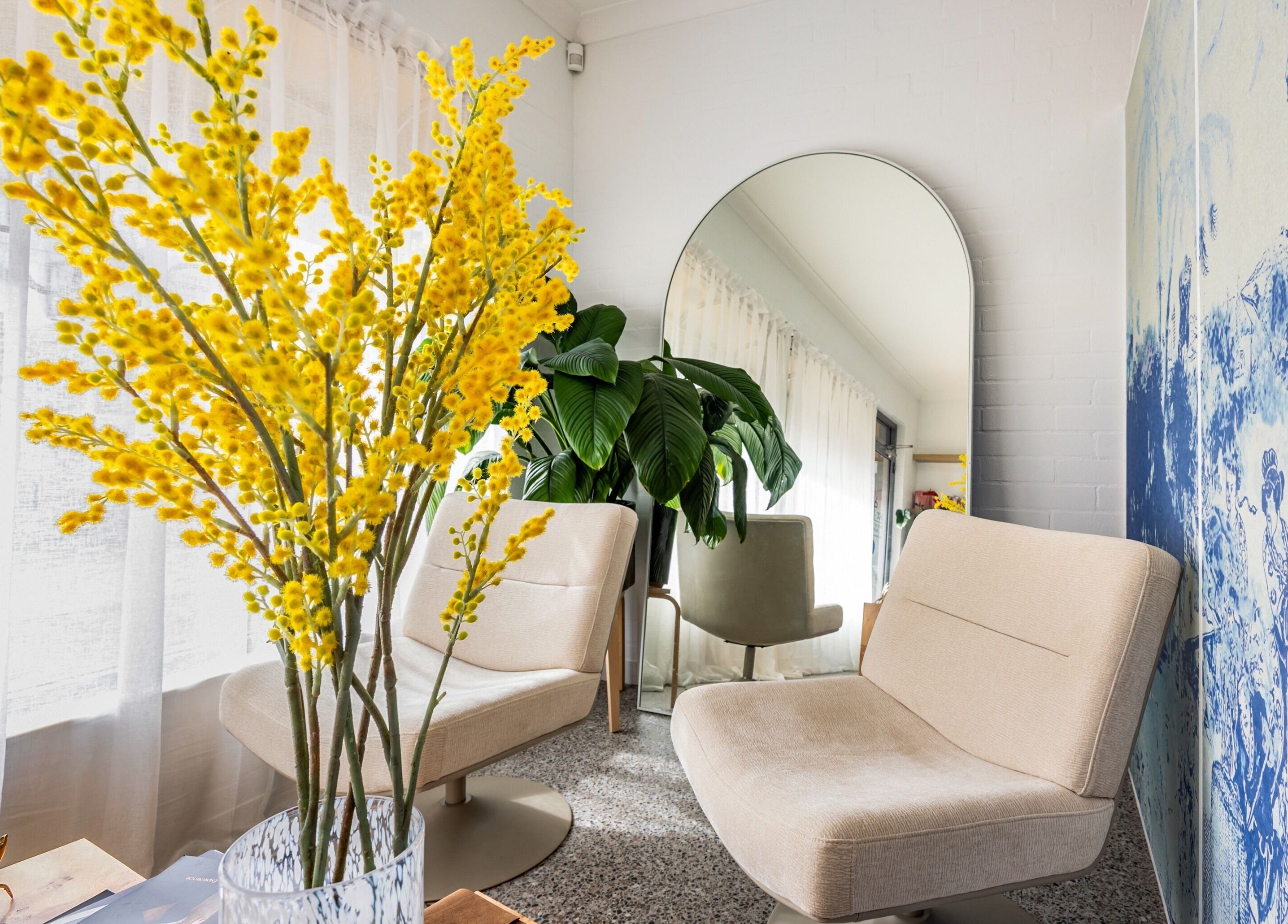 Chic lounge area at Bare Beauty Clinic Sydney, featuring plush chairs and vibrant decor. Sydney, NSW, AU.