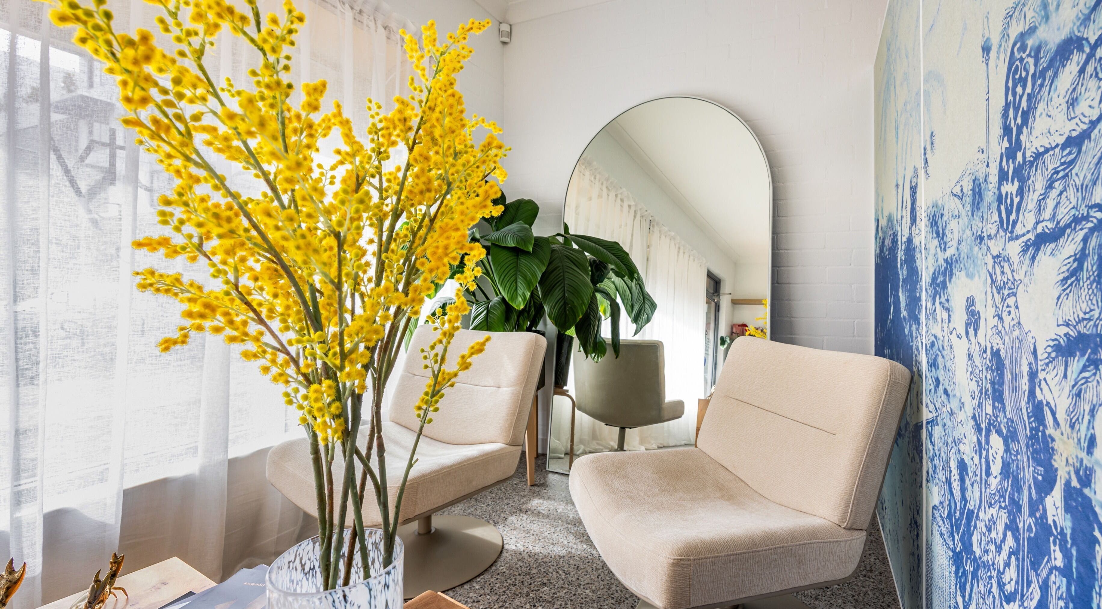 Chic lounge area at Bare Beauty Clinic Sydney, featuring plush chairs and vibrant decor. Sydney, NSW, AU.