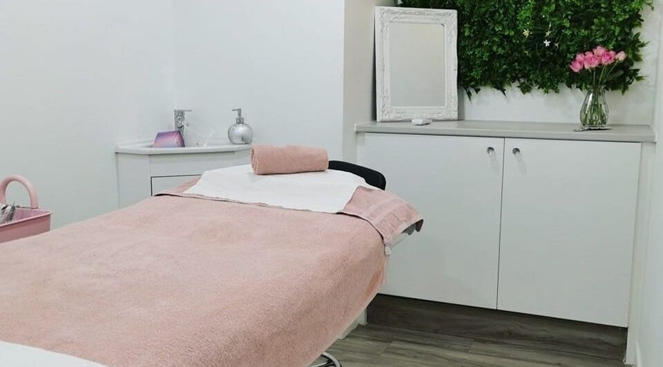 Relaxing treatment room at Eden Beauty House, Ipswich, England, GB, featuring a pink towel and floral decor.