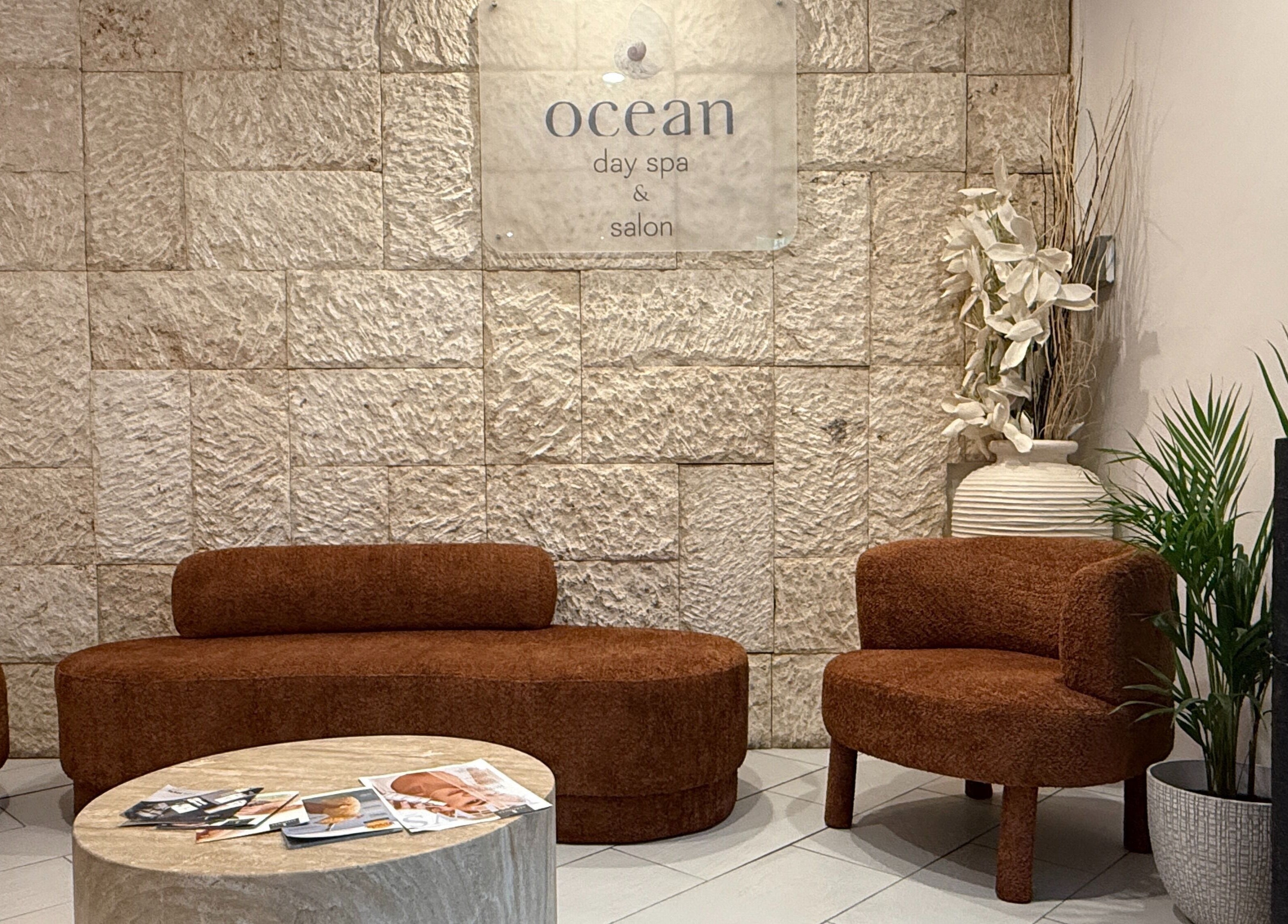 Relax in the welcoming lounge at OCEAN Day Spa, Surfers Paradise, Queensland, AU. Warm decor and comfortable seating.