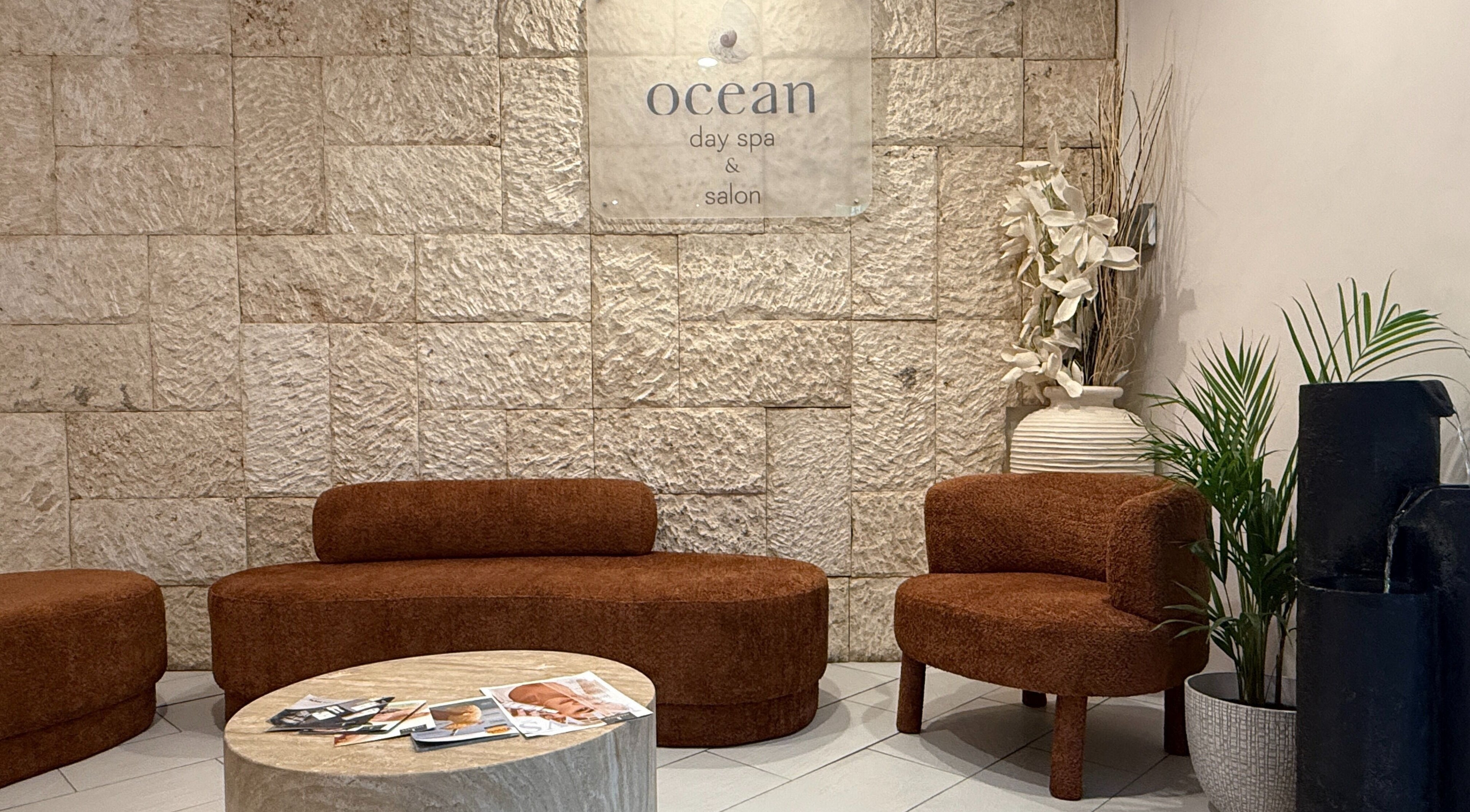 Relax in the welcoming lounge at OCEAN Day Spa, Surfers Paradise, Queensland, AU. Warm decor and comfortable seating.