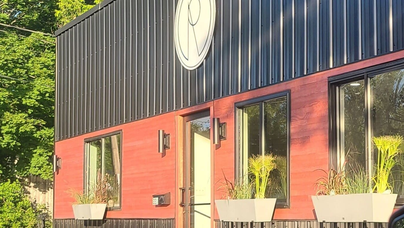Exterior of Gemini Skin + Lash Studio in Winthrop, Maine, US with modern design and vibrant plant decor.