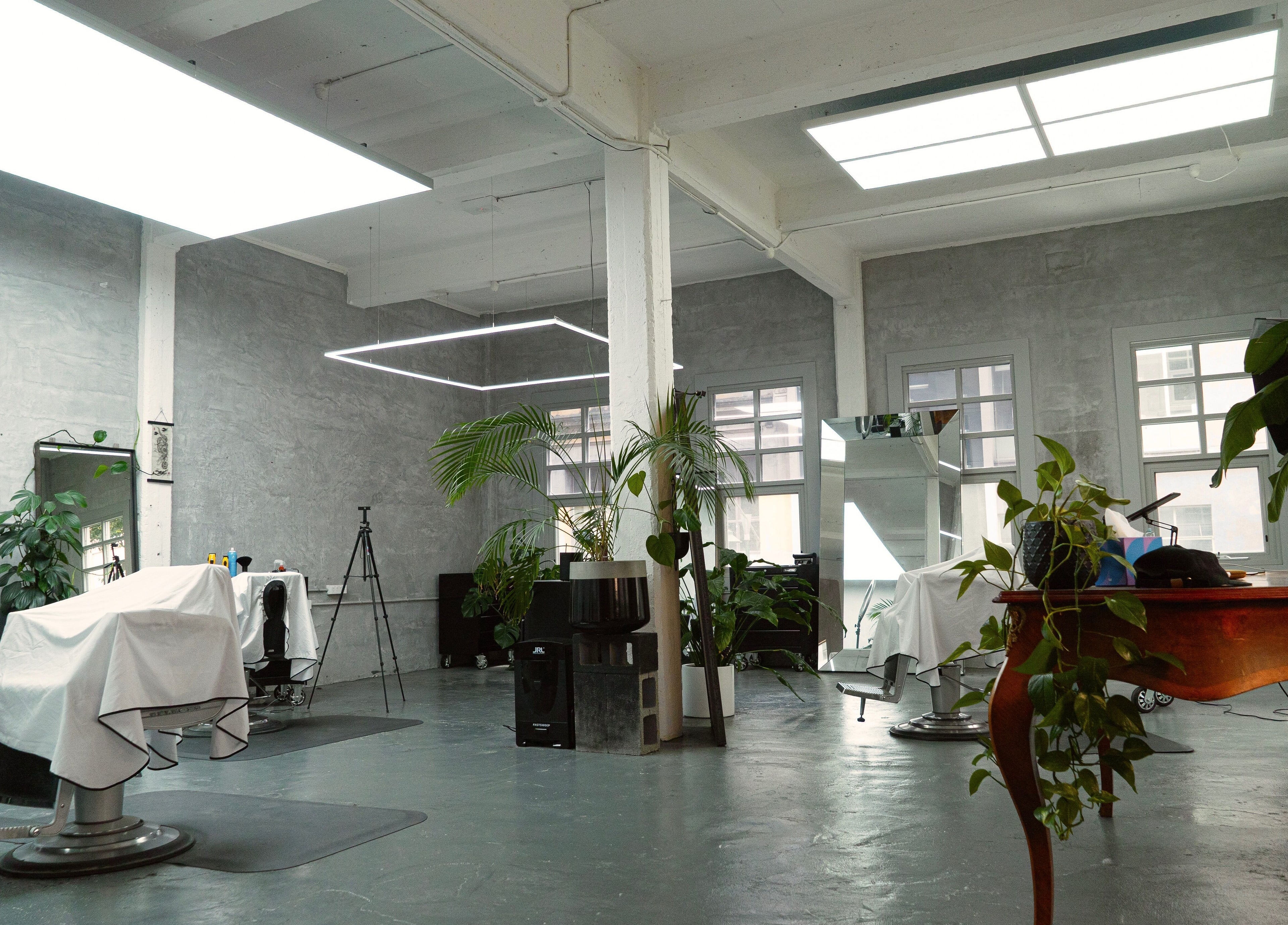 Modern interior of Onyx Studio in Melbourne, Victoria, AU featuring sleek barber chairs and lush green plants.