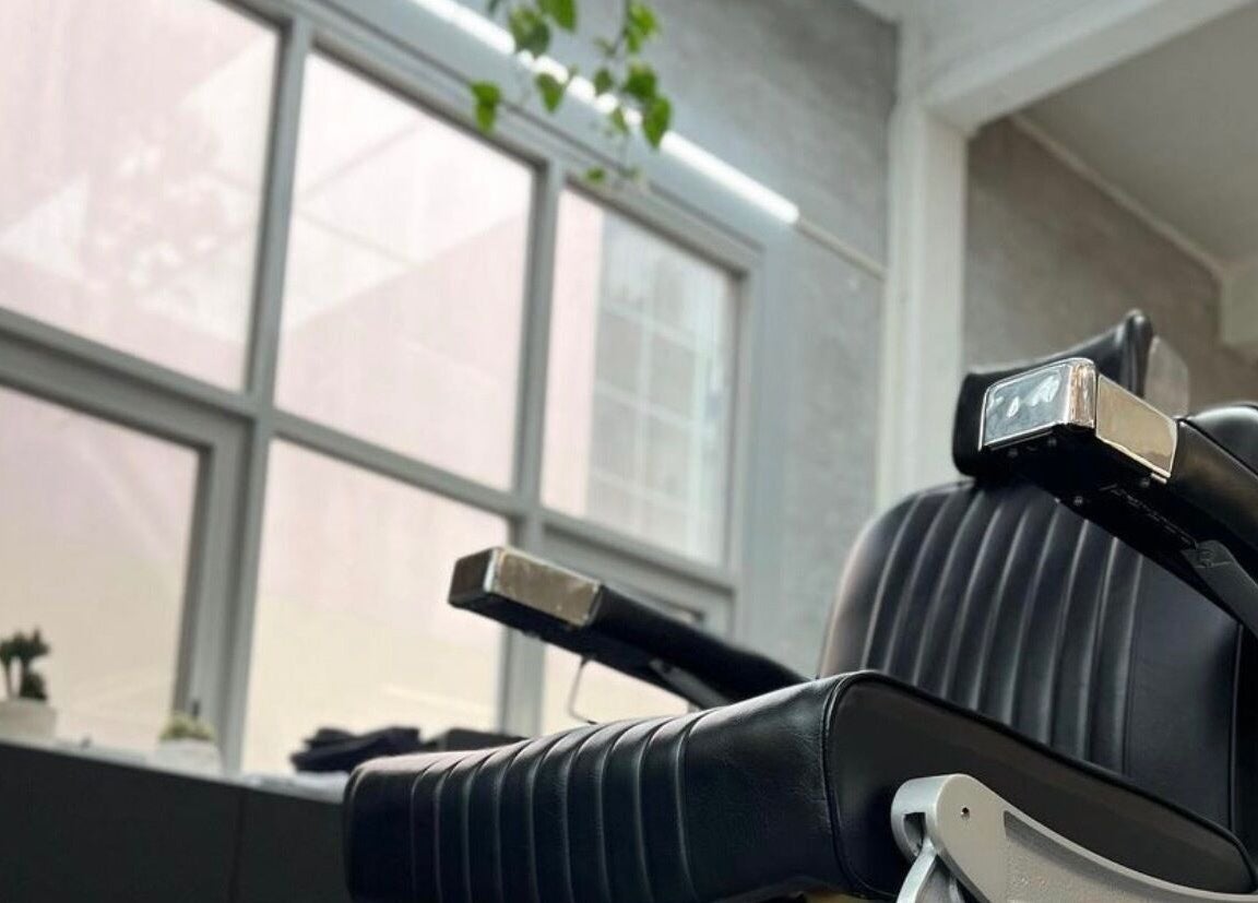 Sleek black barber chair at Onyx Studio in Melbourne, Victoria, AU, offering a modern grooming experience.