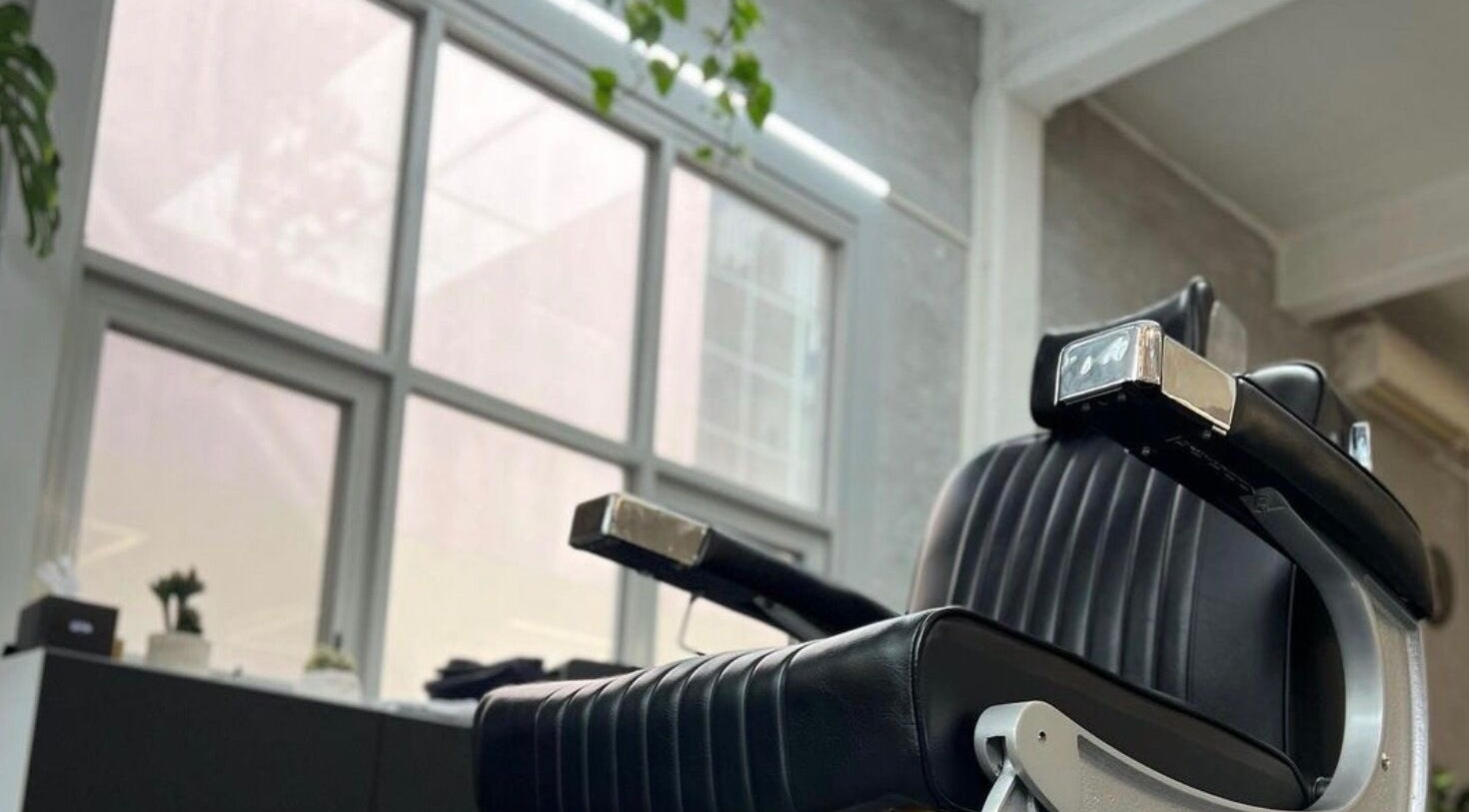 Sleek black barber chair at Onyx Studio in Melbourne, Victoria, AU, offering a modern grooming experience.