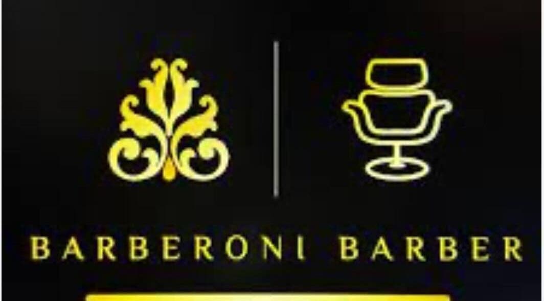 Gold logo of Barberoni Barber in Il-Mellieħa, MT with ornate design and barber chair icon.