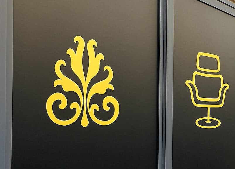 Decorative signage at Barberoni Barber² in Iż-żurrieq, MT showcasing elegant emblem and barber chair.