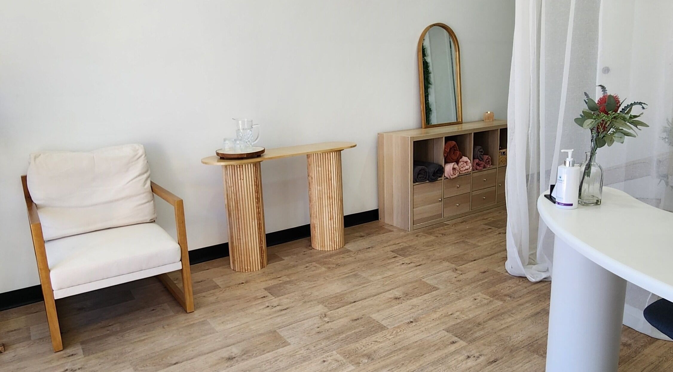 Chic interior of Dluxe Beauty and Brows in Waratah, New South Wales, featuring a cozy chair and modern decor.