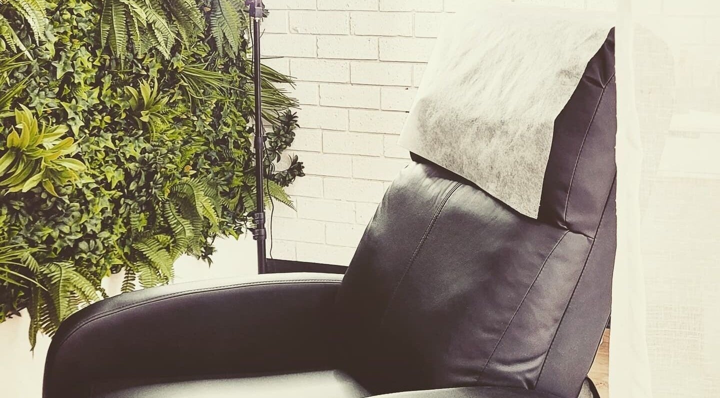 Relaxing treatment chair at Dluxe Beauty and Brows, Waratah, New South Wales, AU, with lush green decor.