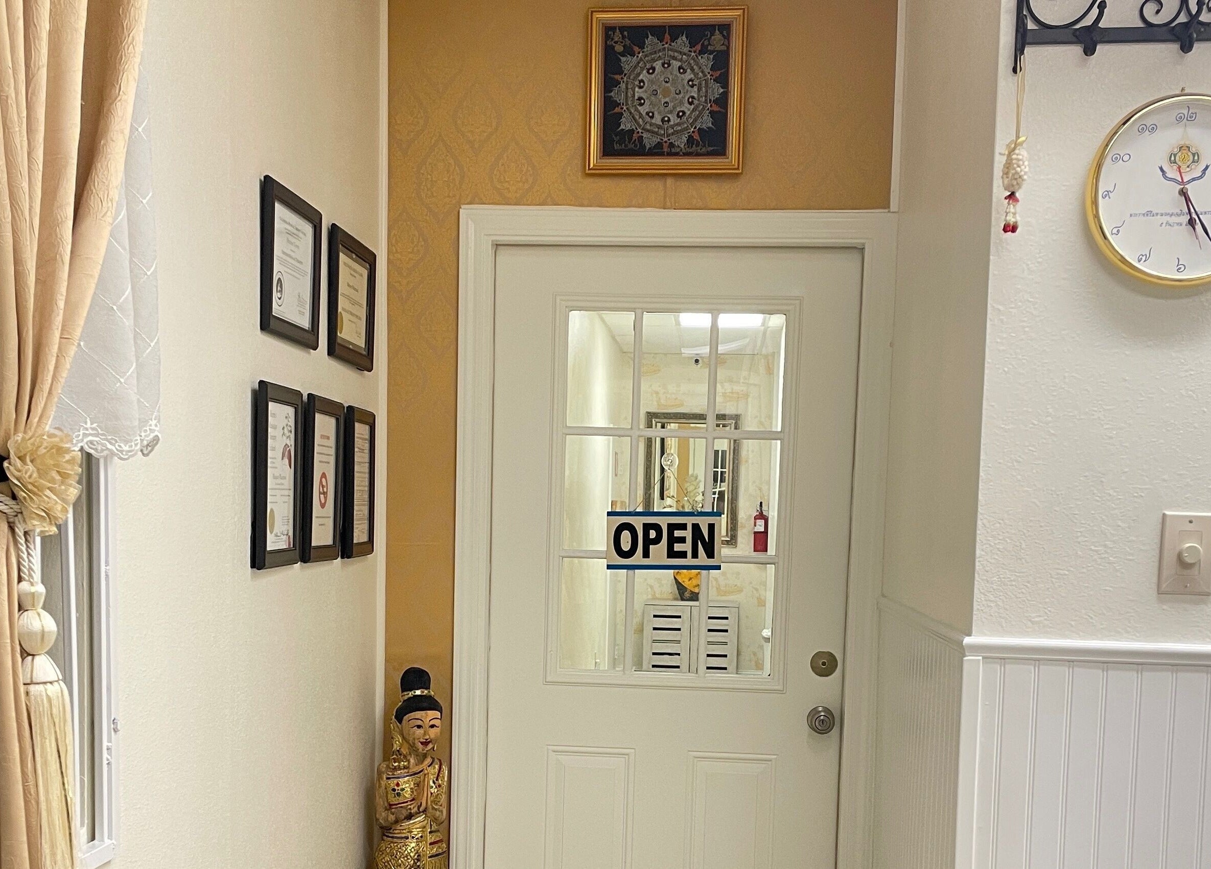 Entrance of Kinnaree Thai Spa in Fresno, California, US, showcasing decor and certificates.