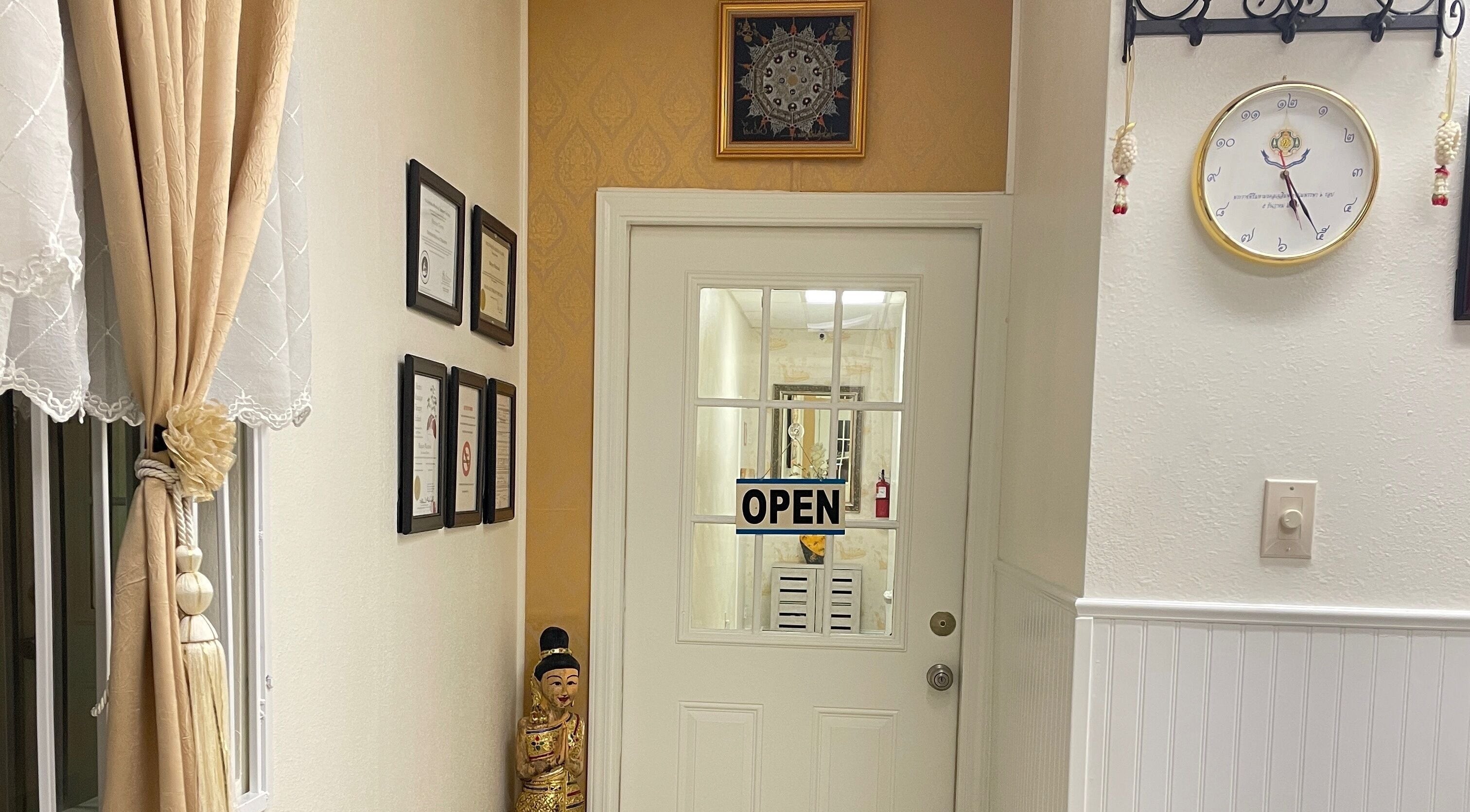 Entrance of Kinnaree Thai Spa in Fresno, California, US, showcasing decor and certificates.