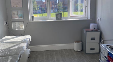 Bright treatment room at Radiant by Julie, Derby, England, GB, featuring certificates and modern decor.