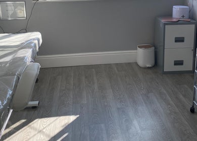 A calm treatment room at Radiant by Julie in Derby, England, GB, featuring a massage table and organized storage.