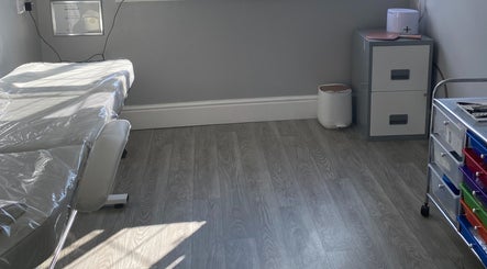 A calm treatment room at Radiant by Julie in Derby, England, GB, featuring a massage table and organized storage.