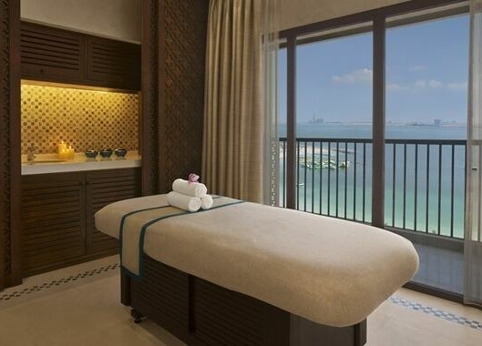 Serene spa room at Jouri Rose Spa, Ras al Khaimah, AE with ocean view and massage table.