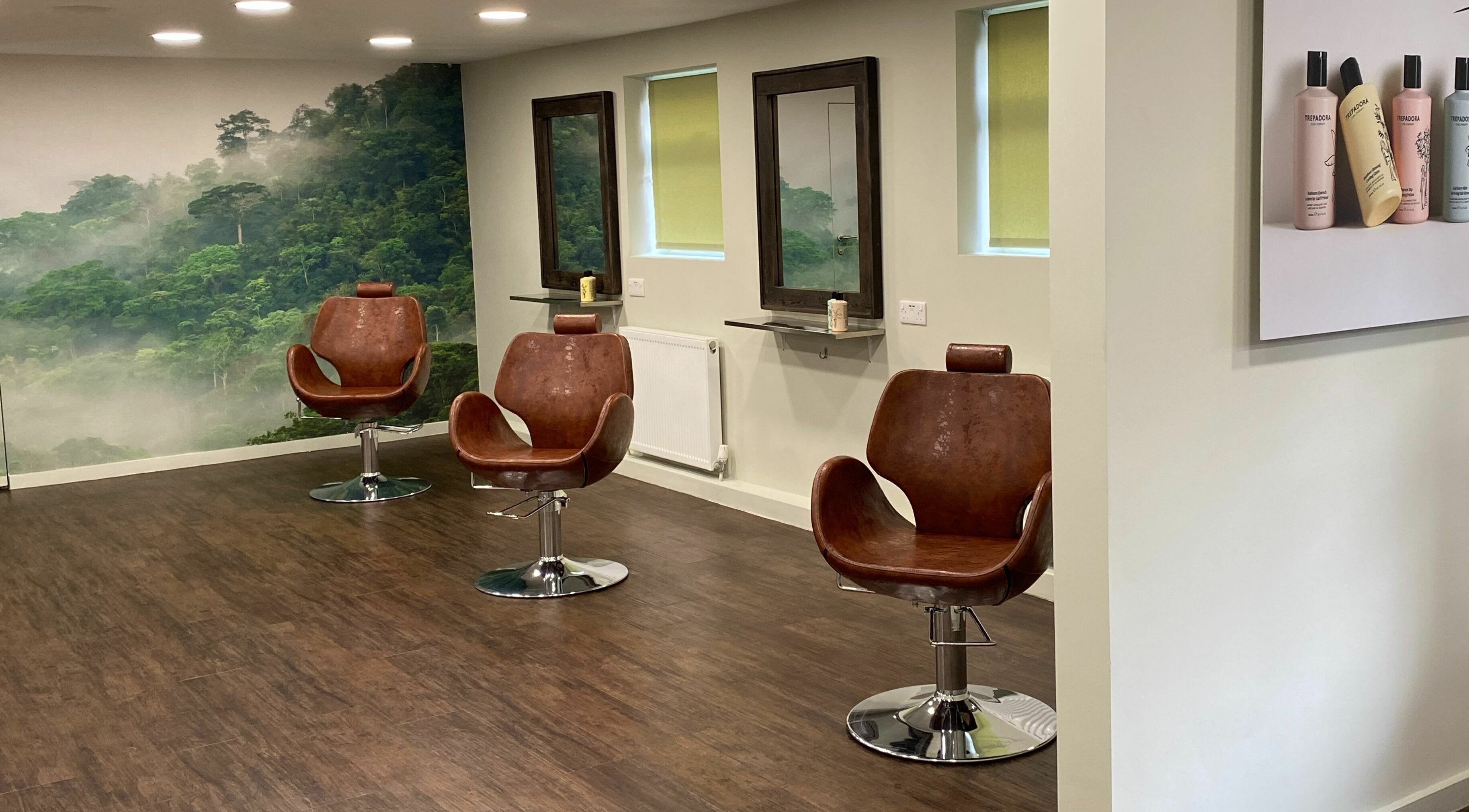 Inside Trepadora Curly Hair Salon in Maidenhead, GB with modern chairs and lush forest wall décor.