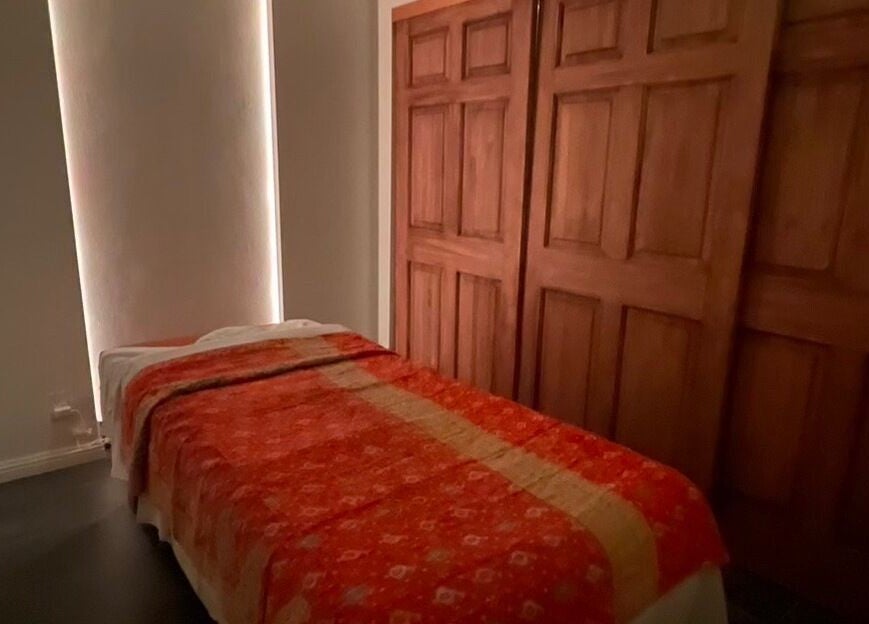 Cozy massage room at SIAM WALA Therapeutic Massage, El Segundo, California, US, with a warm red blanket.
