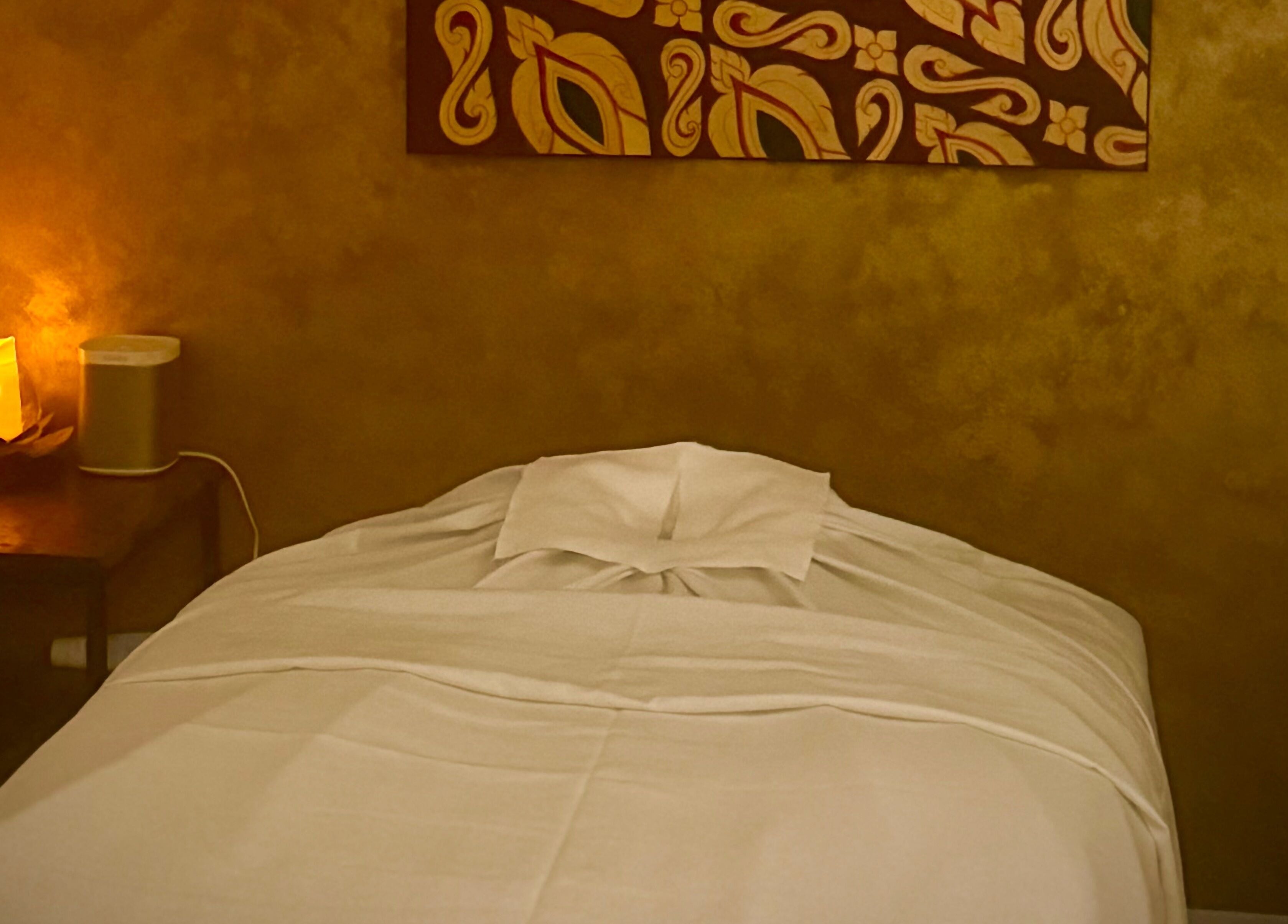 Cozy massage room at SIAM WALA Serenity Spa in Torrance, California, US, with warm lighting and elegant decor.