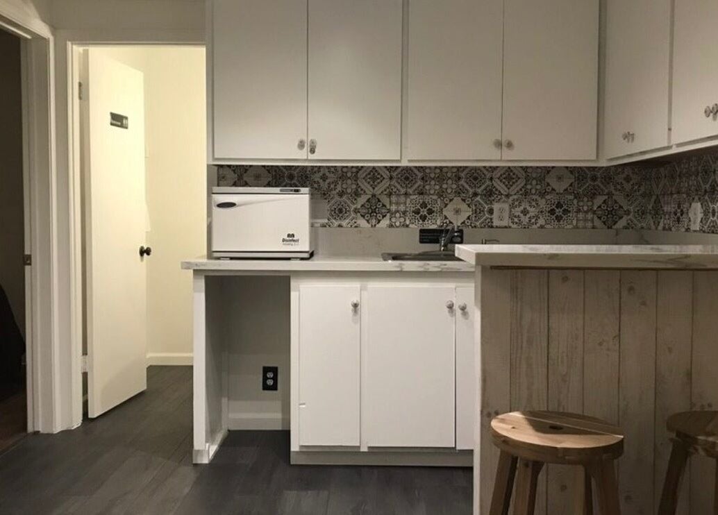 Modern kitchenette area at SIAM WALA Serenity Spa in Torrance, California, US with stylish cabinetry and stools.