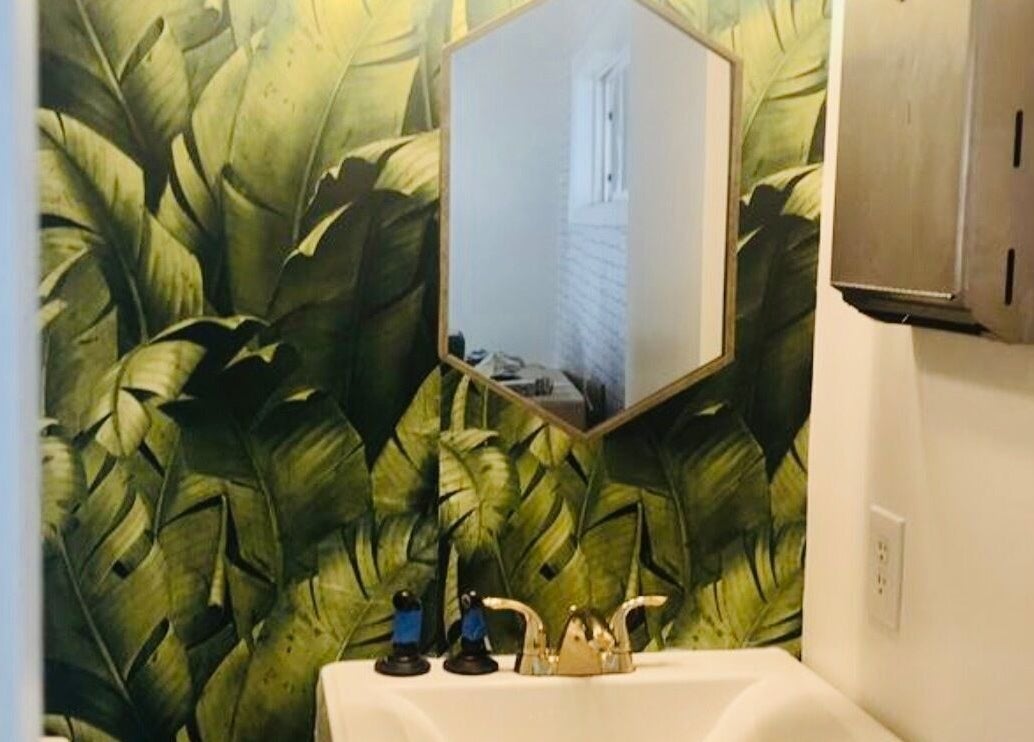 Hexagonal mirror and tropical wallpaper in SIAM WALA Serenity Spa's restroom, Torrance, California, US.