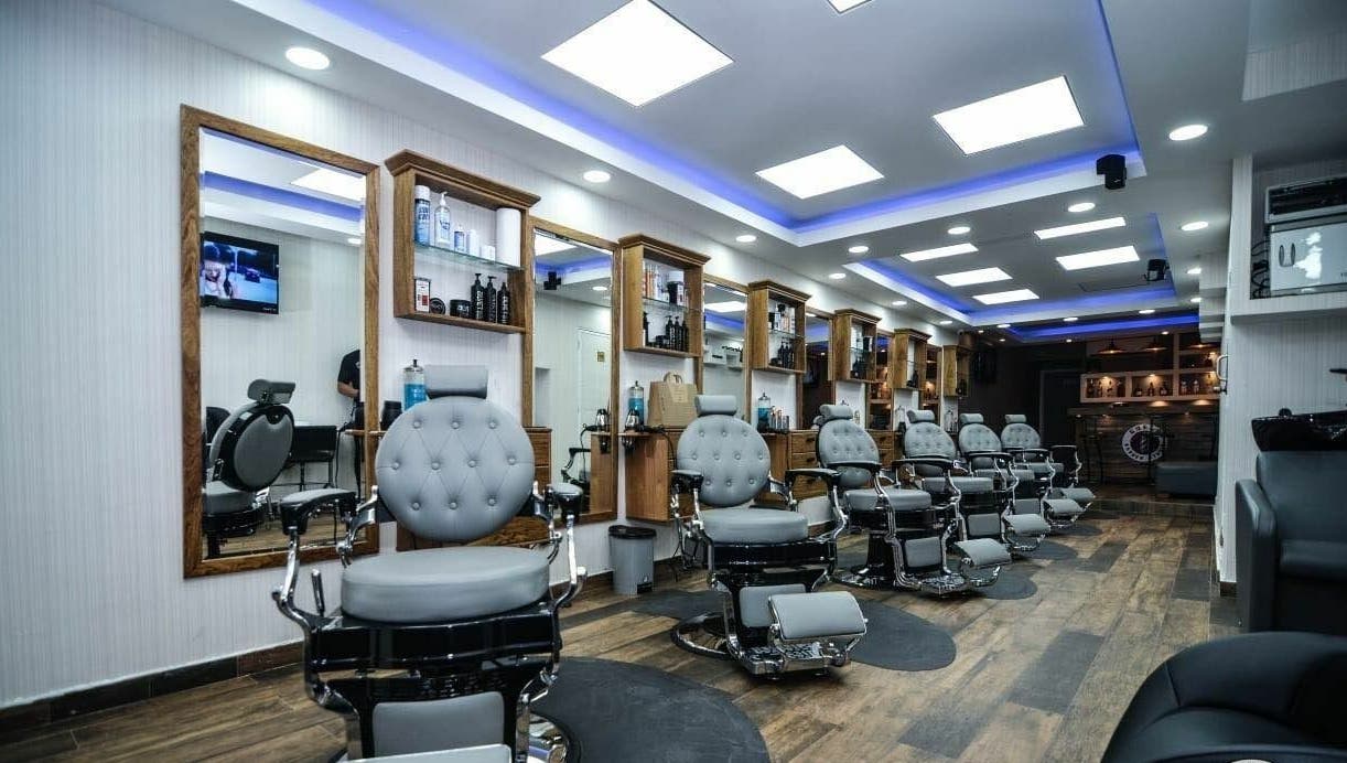 Spacious modern interior of Guelo Barber Studio in Santo Domingo, DO featuring chic barber chairs.