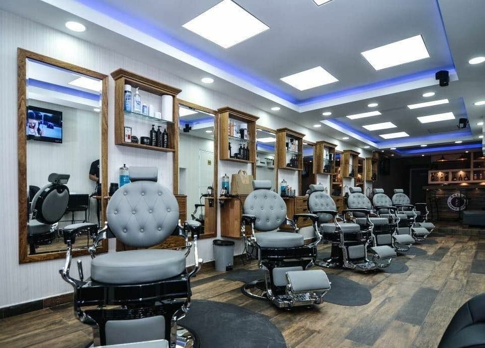 Spacious modern interior of Guelo Barber Studio in Santo Domingo, DO featuring chic barber chairs.