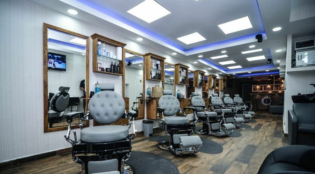 Spacious modern interior of Guelo Barber Studio in Santo Domingo, DO featuring chic barber chairs.