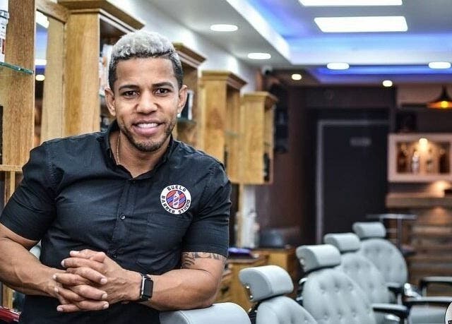 Friendly barber at Guelo Barber Studio, Santo Domingo, DO, ready to serve clients in a modern, stylish setting.