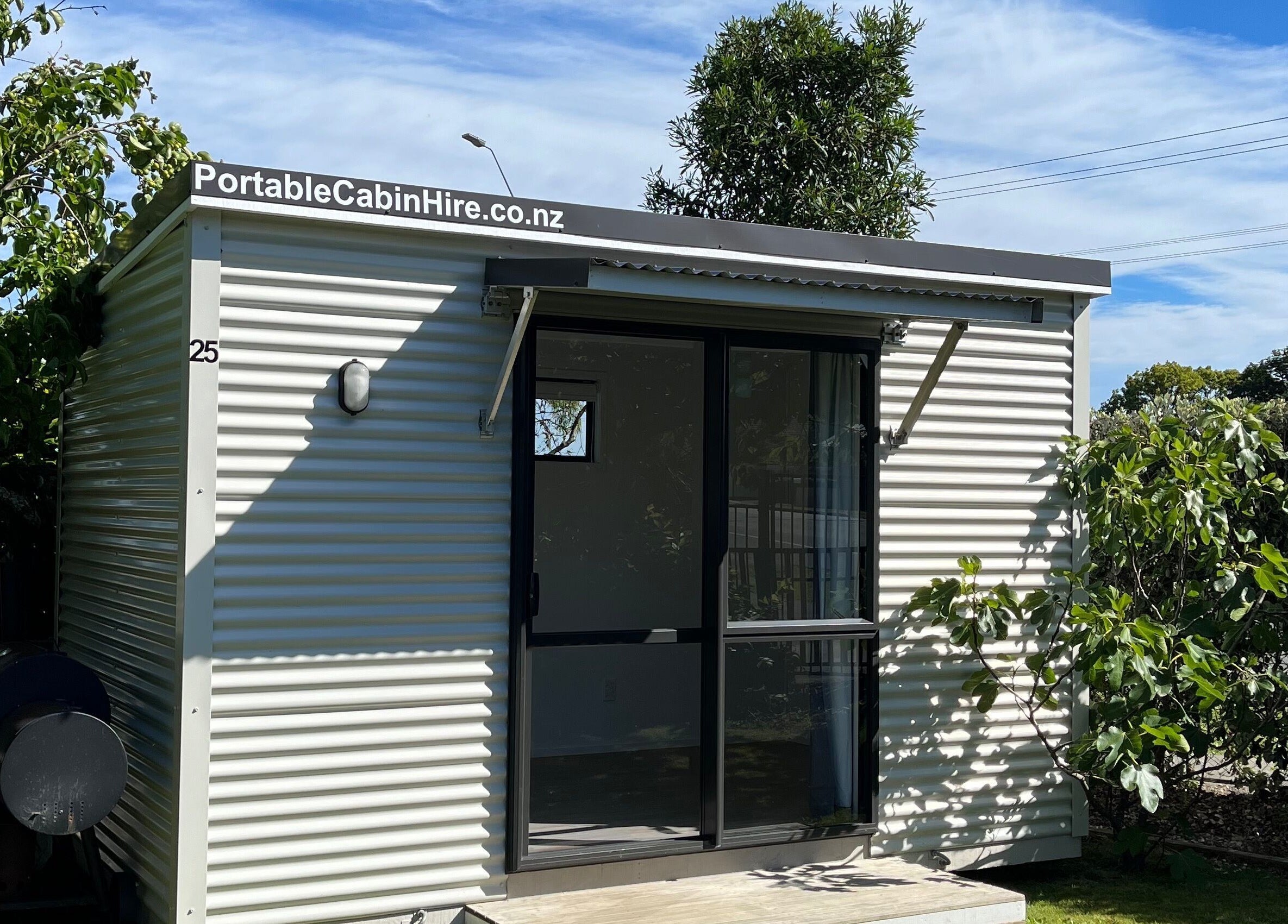 Charming portable cabin exterior at GeLest Nails, Nelson, Nelson, NZ, surrounded by lush greenery.
