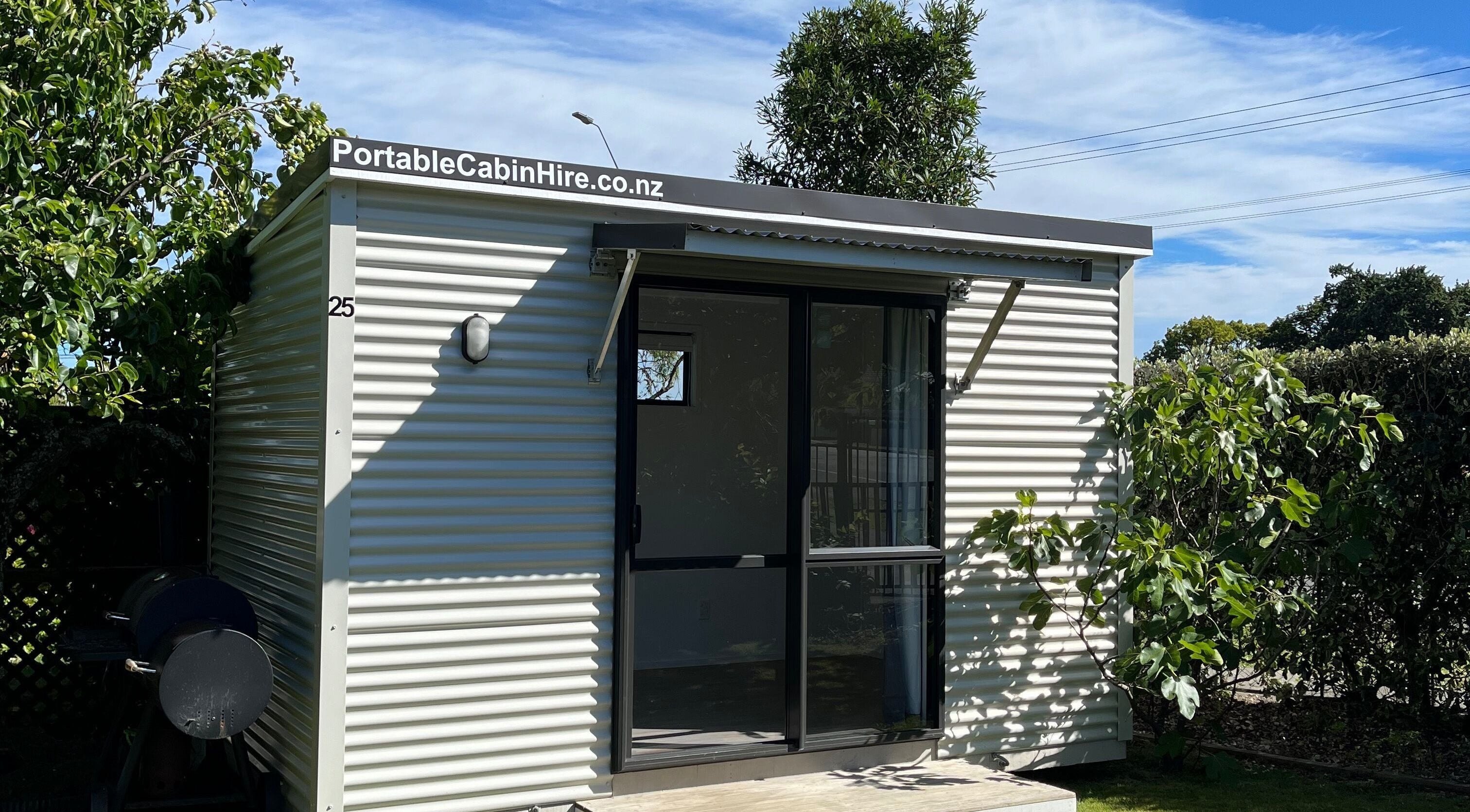 Charming portable cabin exterior at GeLest Nails, Nelson, Nelson, NZ, surrounded by lush greenery.