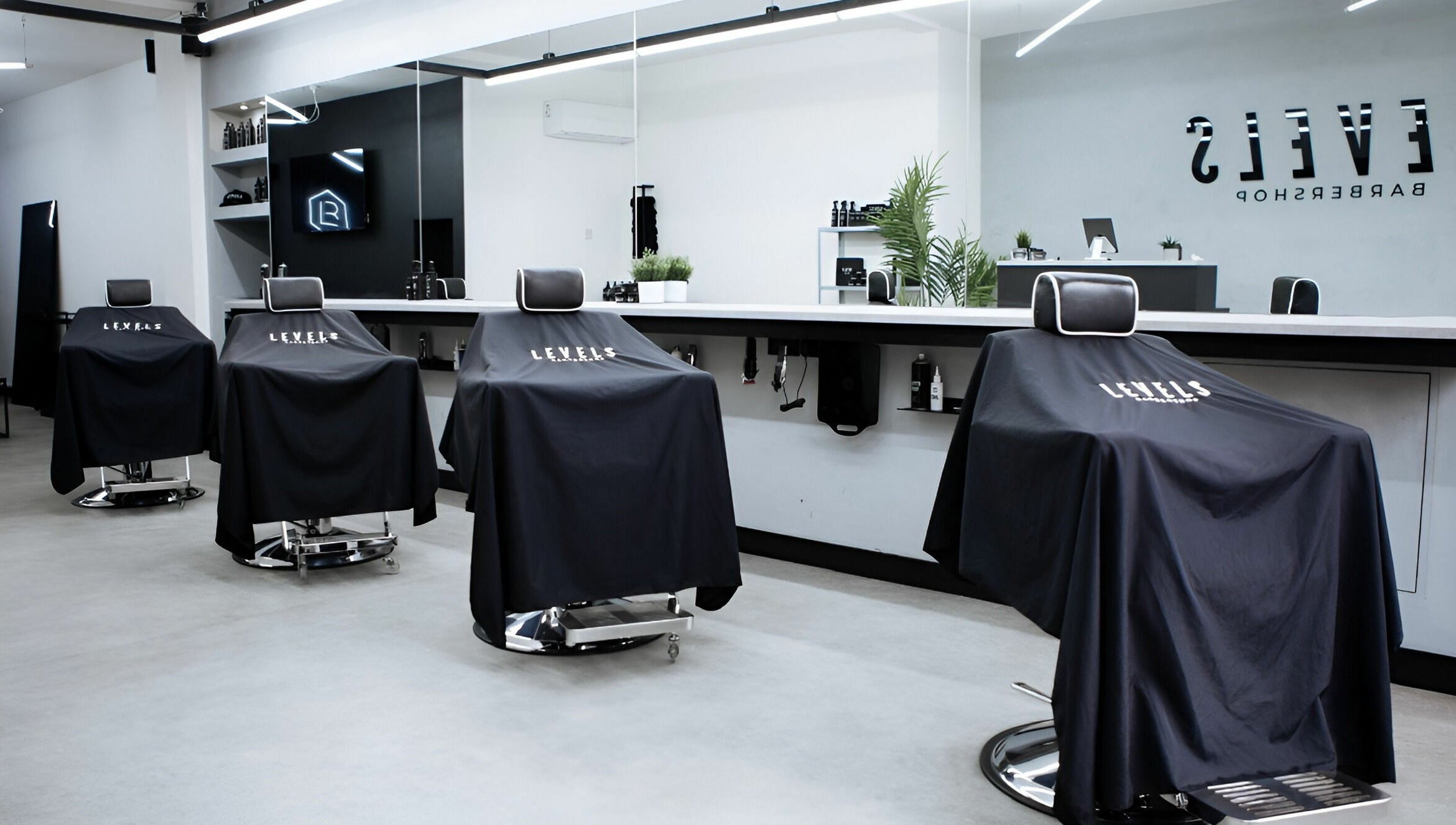 Modern barber chairs in Levels Mens Grooming, Newton Abbot, England, GB, showcasing sleek interior design.