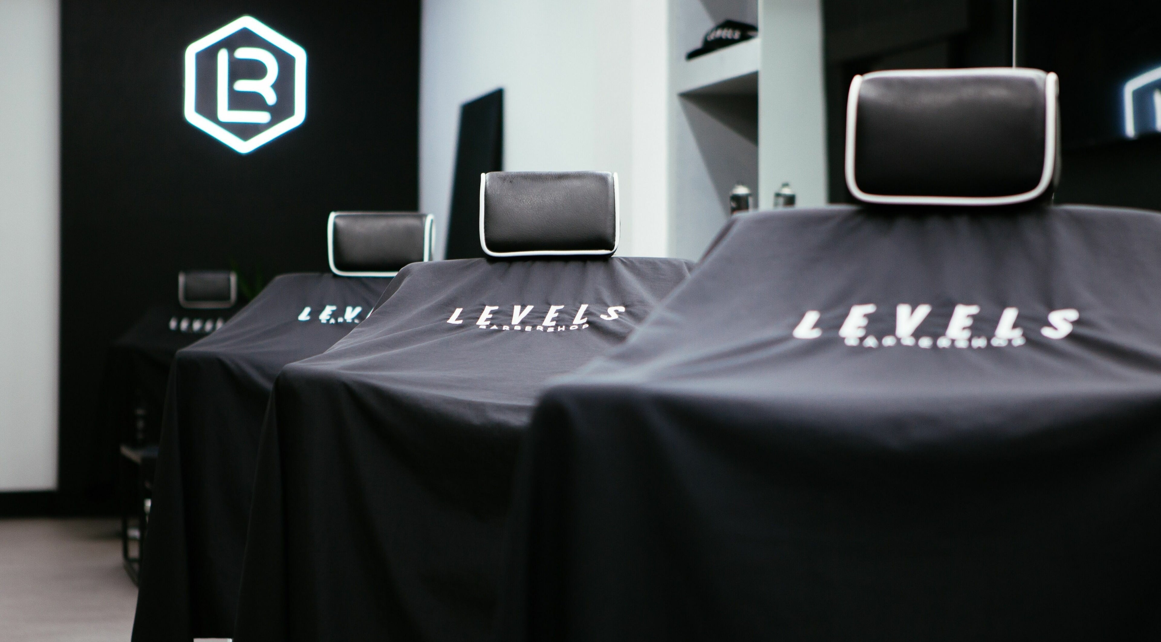 Stylish barber chairs at Levels Mens Grooming in Newton Abbot, England, GB. Sleek black design enhances modern feel.