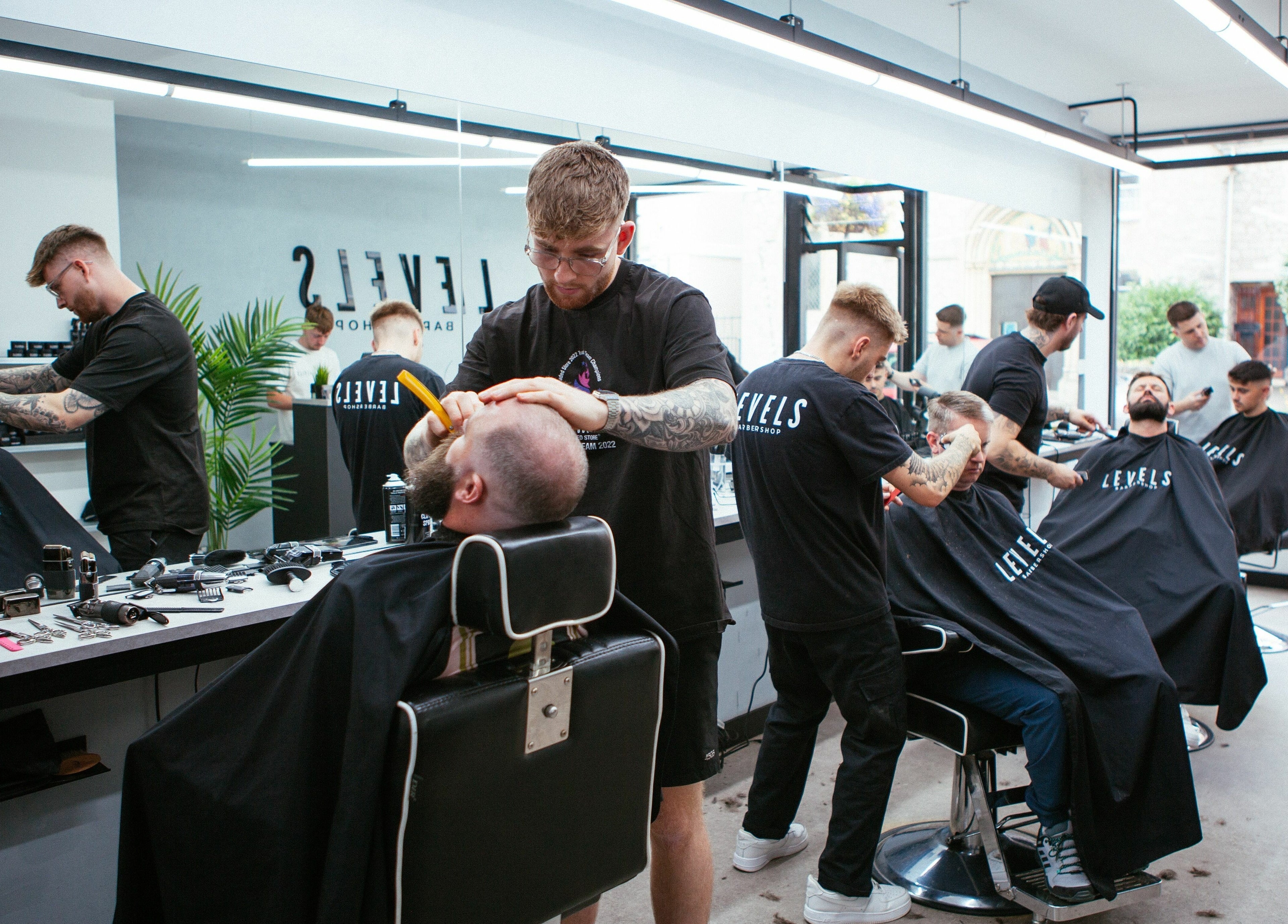 Stylists busy at Levels Mens Grooming, Newton Abbot, England, GB, creating trendy haircuts.