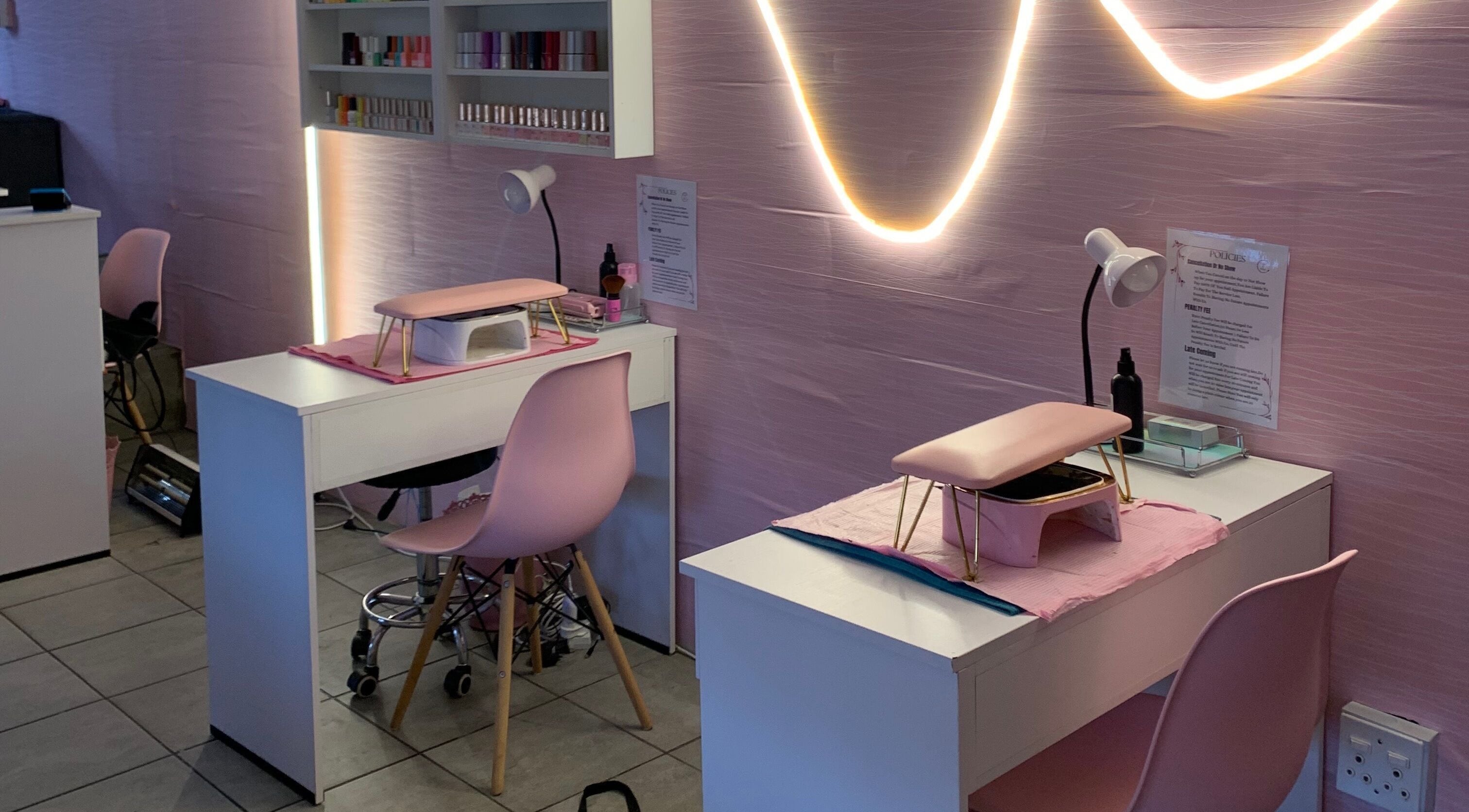 Stylish nail salon setup at Me Myself And Nails, Soweto, Gauteng, ZA with pink decor and modern lighting.