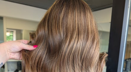 Luxurious brown hair styled at Hair by Karina Brown in Leeds, England, GB, highlighted by a vibrant pink nail.