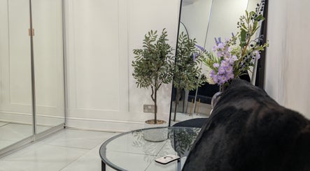 Elegant waiting area with mirror, plants, and a glass table at Hair by Karina Brown, Leeds, England, GB.