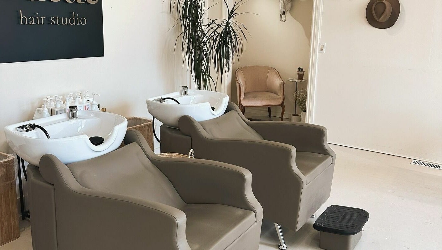 Modern wash stations at Odette Hair Studio, Prince Edward, Ontario, CA with stylish chairs and decor.