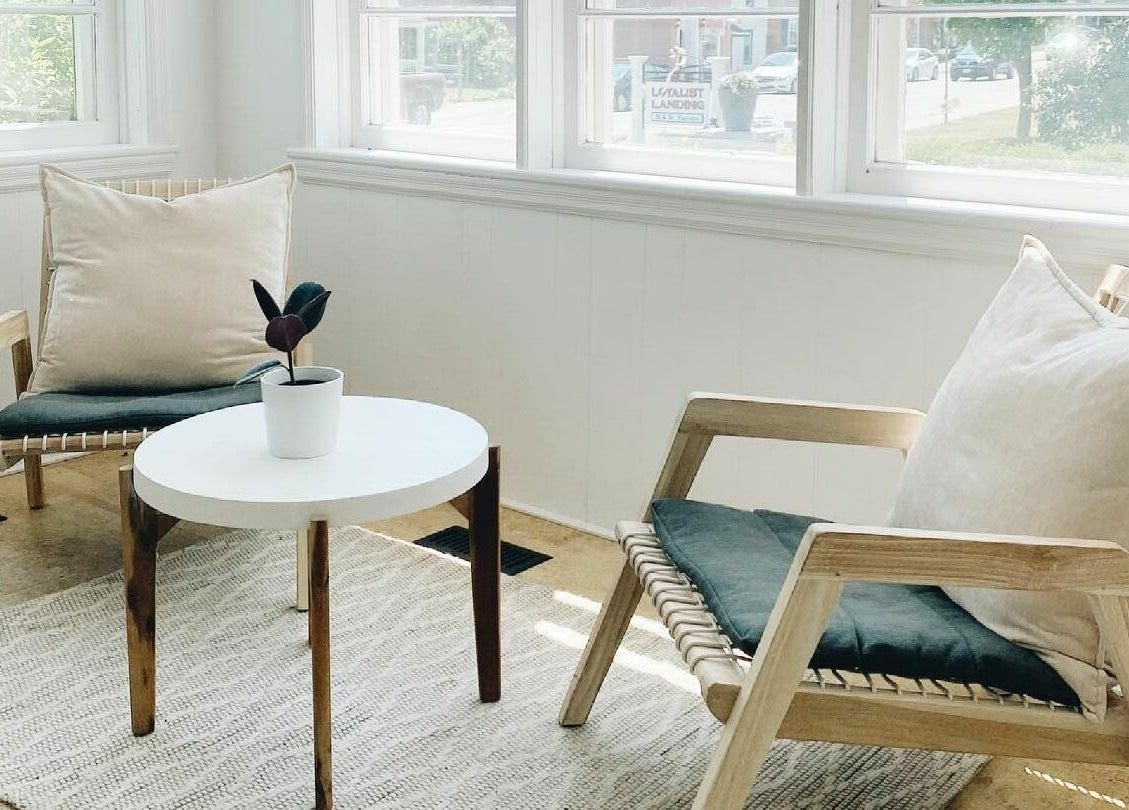 Relaxing seating area at Odette Hair Studio, Prince Edward, Ontario, CA with cozy chairs and a plant.