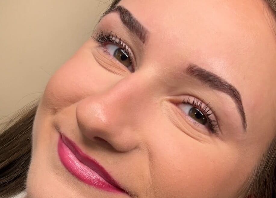 Smiling woman post-treatment at Belle & Radieuse in Laval, Québec, CA showcasing smooth skin and defined eyebrows.