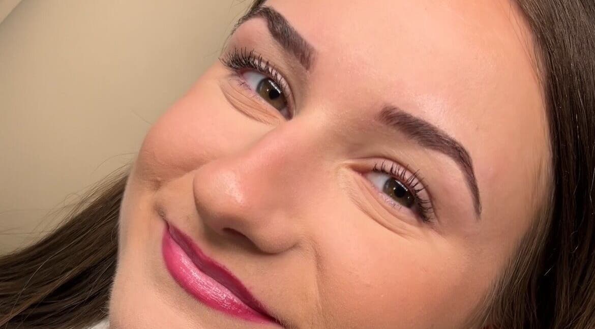 Smiling woman post-treatment at Belle & Radieuse in Laval, Québec, CA showcasing smooth skin and defined eyebrows.