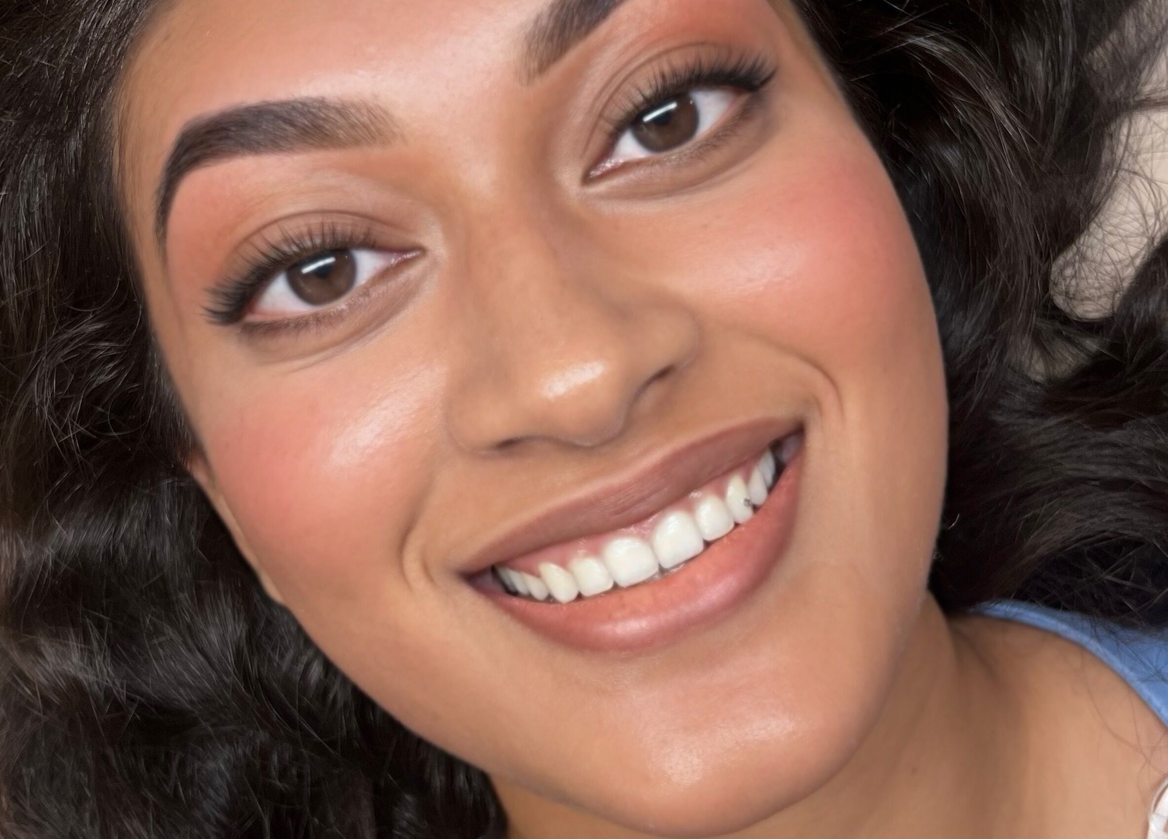 Woman smiling with radiant makeup at Belle & Radieuse, Laval, Québec, CA.