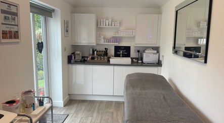 Calm treatment room at Skin Solutions in Church Crookham, England, GB, featuring a cozy bed and beauty products.