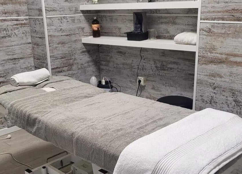 Sala de tratamiento en The Salon Benalmadena, Benalmádena, Andalucía, ES, con decoración rústica y cama acogedora.