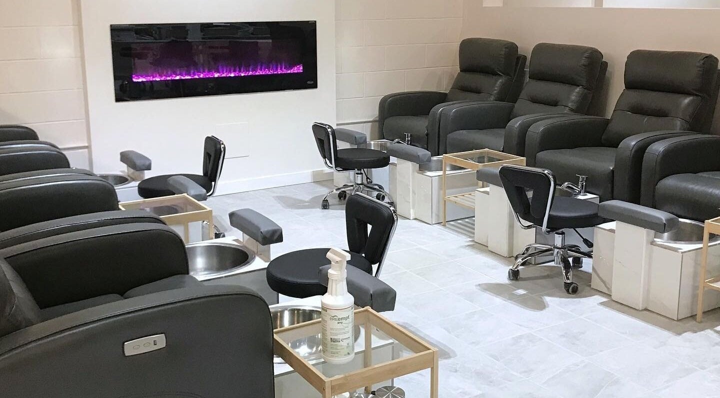 Pedicure chairs with a modern fireplace at Sugar Beauty Bar, Ottawa, Ontario, CA.