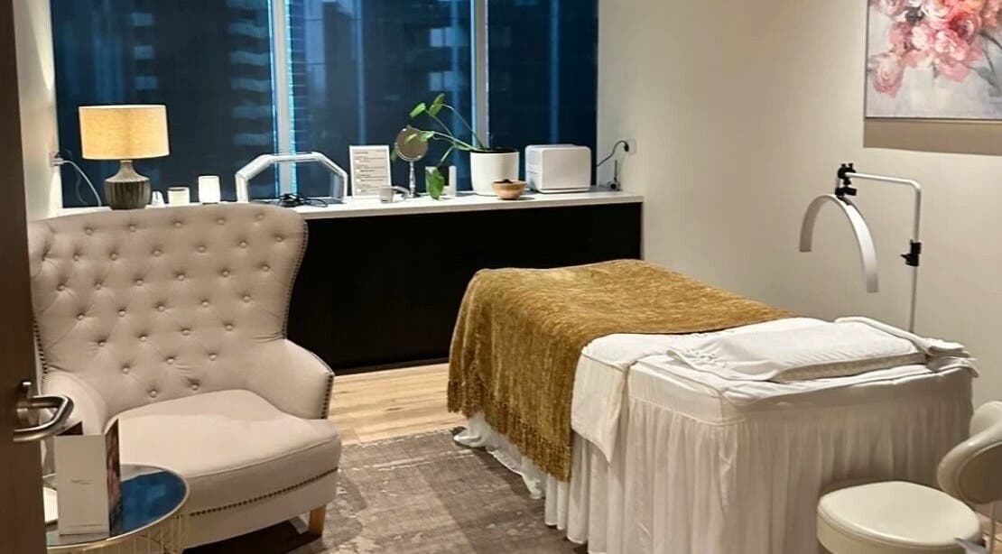Relaxing treatment room at Snowy Medispa, Melbourne, Victoria, AU featuring a plush chair and massage bed.