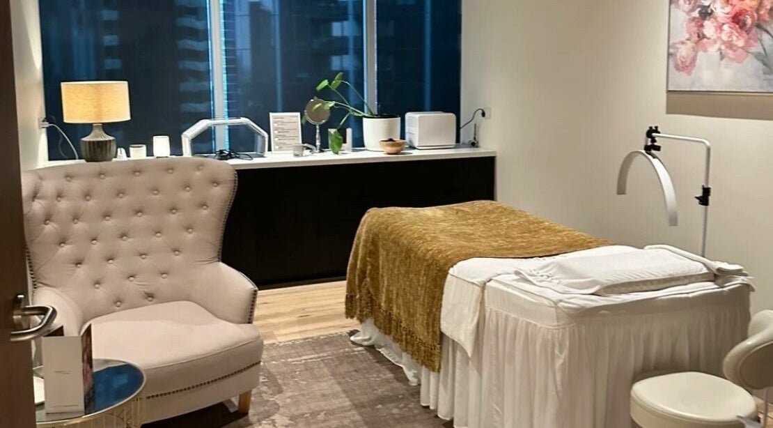 Relaxing treatment room at Snowy Medispa, Melbourne, Victoria, AU featuring a plush chair and massage bed.