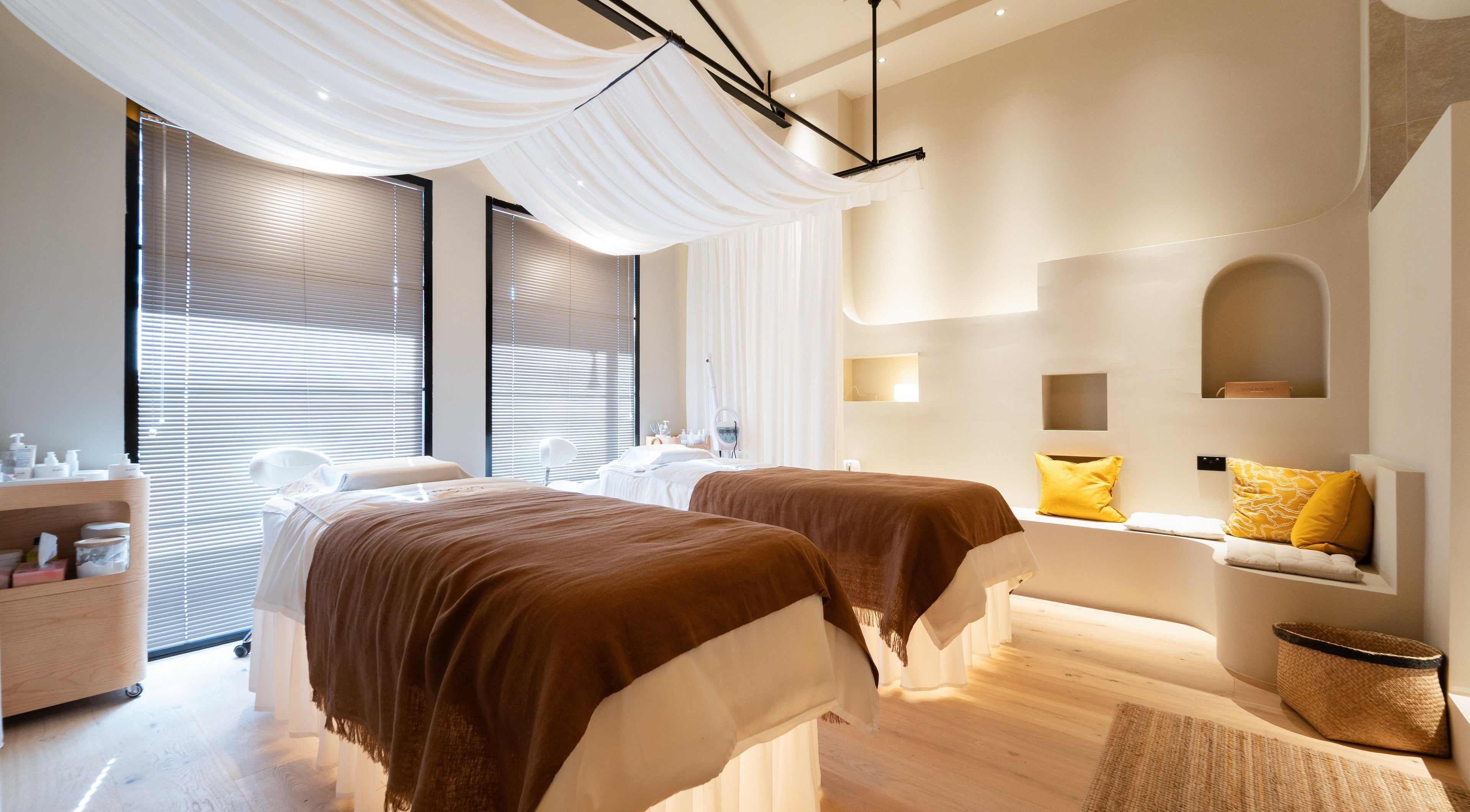 Relaxing treatment room at Snowy Season in Melbourne, Victoria, AU with two massage tables and soft lighting.
