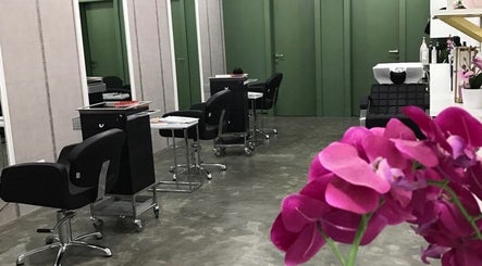 Stylish interior of Color Cravings Beauty Salon in Bu Quwah, with modern chairs and vibrant orchids.